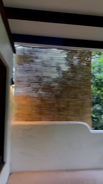 Warm exterior lighting on a rendered wall and timber screen